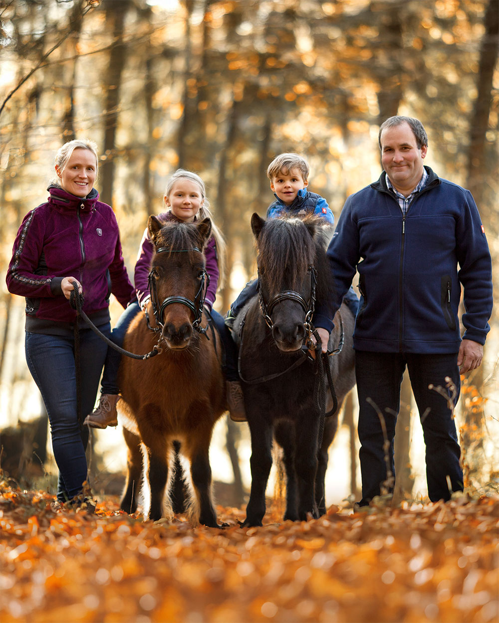 Familie Reinke-Becker mit zwei Ponys im herbstlichen Wald