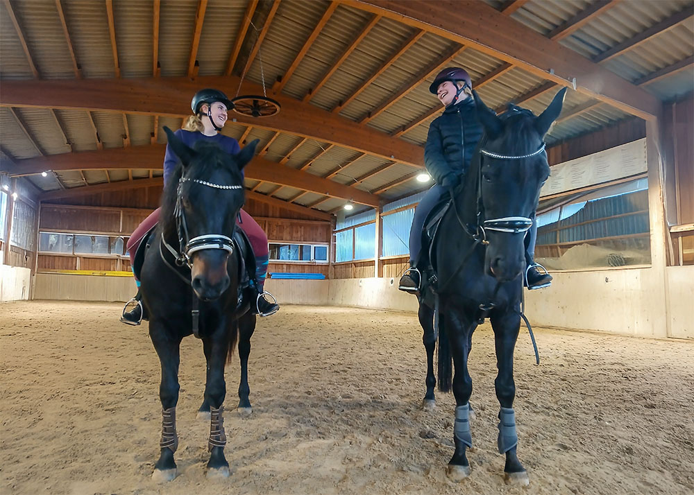 Zwei Reiter auf Pferden in der Reithalle des Berishof in Flieden